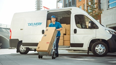 delivery-man-pushes-hand-truck-260nw-1701403291